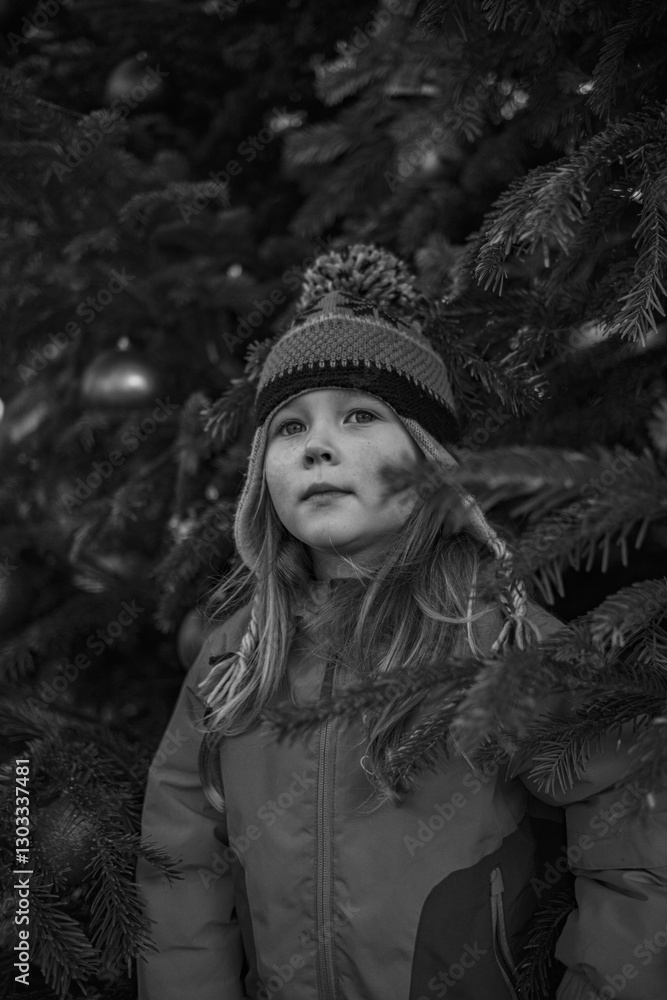 Little girl 5 years old in a winter jacket and hat near the New Year tree Little girl 5 years old in a winter jacket and hat near the New Year tree