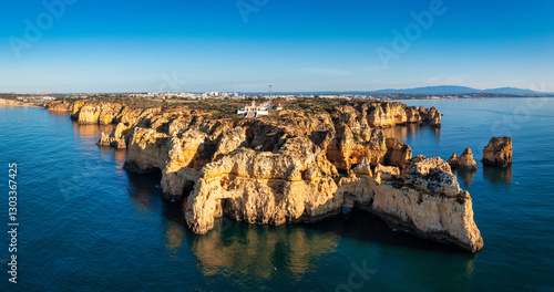 Panoramic view, Ponta da Piedade near Lagos in Algarve, Portugal. Cliff rocks and tourist boat on sea at Ponta da Piedade, Algarve region, Portugal. Ponta da Piedade, Algarve region, Portugal.
