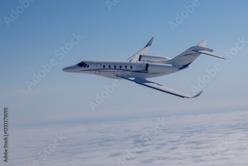 Side view of a Citation X (business jet) over  cloud layers, in beautiful light