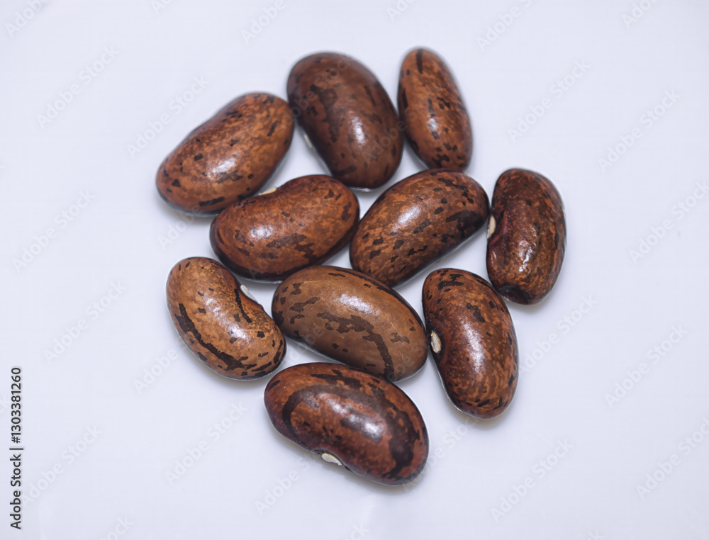Brown pinto beans on a white background close -up. Brown pinto beans on a white background close -up.
