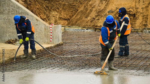 Workers are pouring structural concrete at a construction site