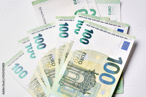 A stack of euro banknotes with the number 100 on them. The banknotes are green and white
