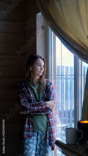 Sad thoughtful woman at home looking out window alone. Winter depression - seasonal affective disorder mental health