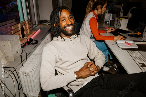 Portrait of happy male entrepreneur relaxing on office chair near desk