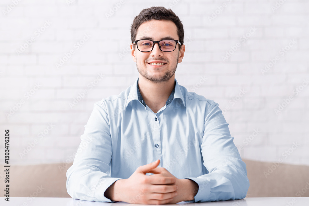 Happy businessman in glasses looking at web camera, making e-coaching conference and video call at living room interior, free space Happy businessman in glasses looking at web camera, making e-coaching conference and video call at living room interior, free space