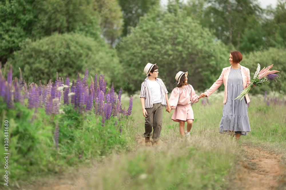 Fototapeta premium Caucasian family stroll: mother with son and daughter in nature holding flowers