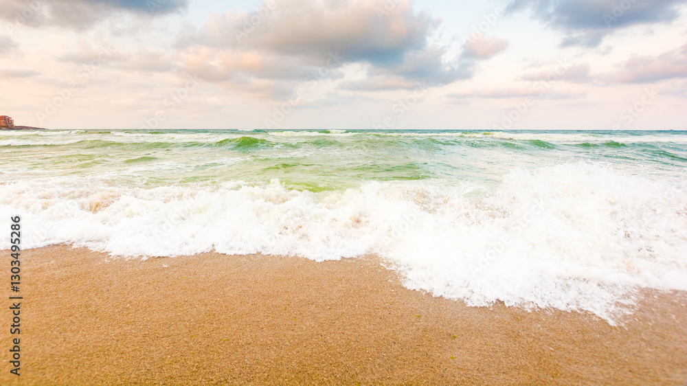 wave washing the sandy beach. velvet season. cloudy weather. scenery at the black sea in evening light. natural environment