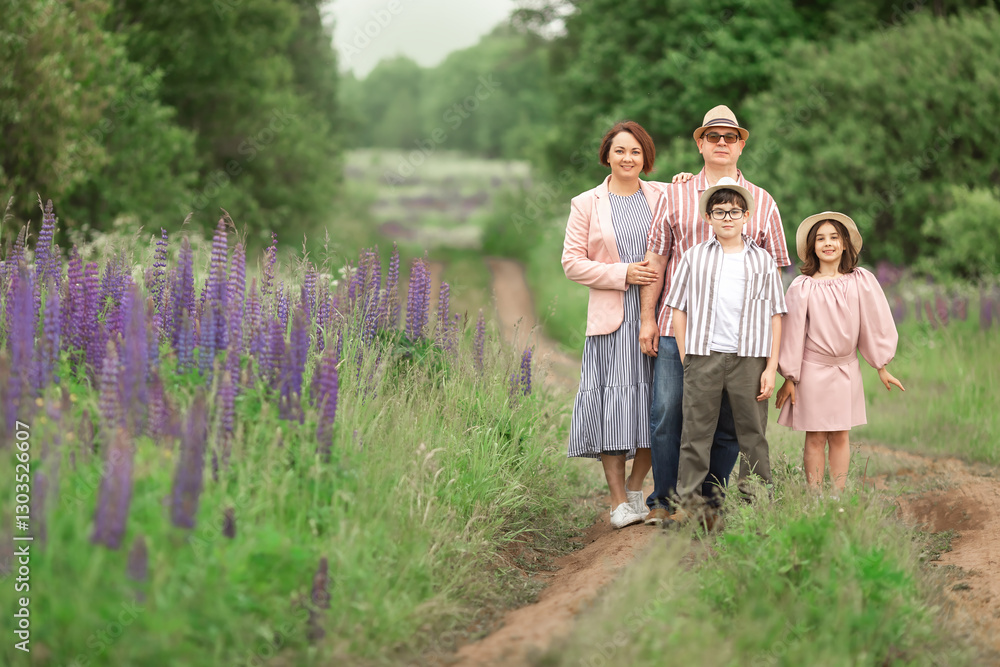 Caucasian family posing in flower field with parents and children enjoying nature Caucasian family posing in flower field with parents and children enjoying nature