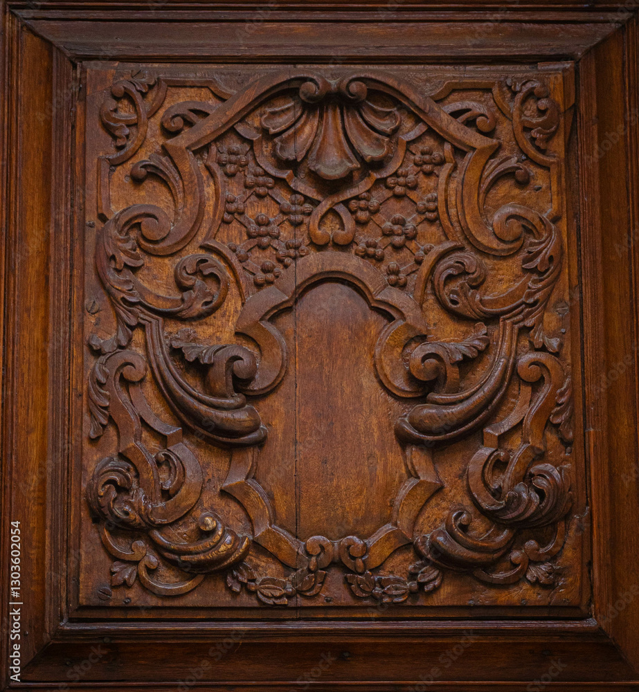 Intricate wood carving on a door panel with a round knob. Decorative design, brown wood, craftsmanship. Vintage style, architectural detail. Intricate wood carving on a door panel with a round knob. Decorative design, brown wood, craftsmanship. Vintage style, architectural detail.