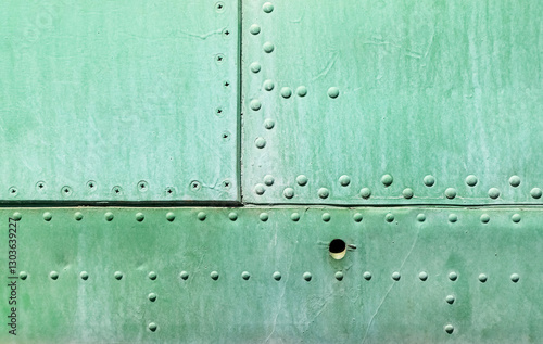 Riveted metal plate painted in green as a steampunk industrial background