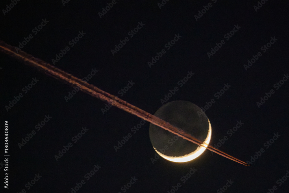 Fototapeta premium Ein Passagierflugzeug fliegt vor dem Mond vorbei