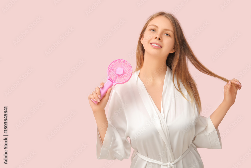 Beautiful young woman with handheld mini fan on pink background Beautiful young woman with handheld mini fan on pink background