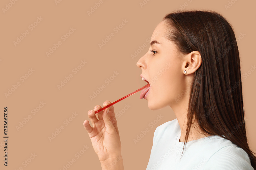 Beautiful young woman with tongue scraper on brown background Beautiful young woman with tongue scraper on brown background