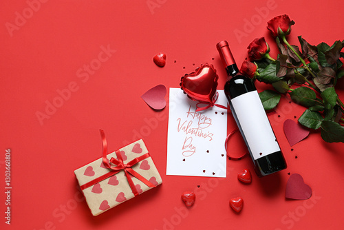 Bottle of wine with postcard, roses and gift on red background. Valentine's Day celebration