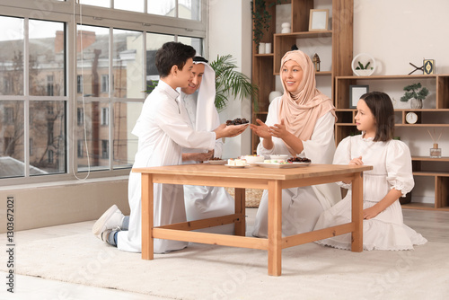Happy Muslim family sitting...
