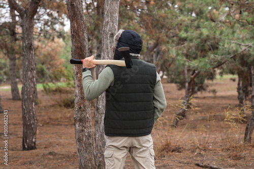Male lumberjack with axe in...