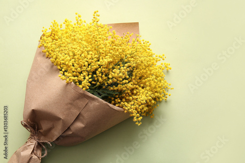 Bouquet of beautiful yellow mimosa flowers on green background photo