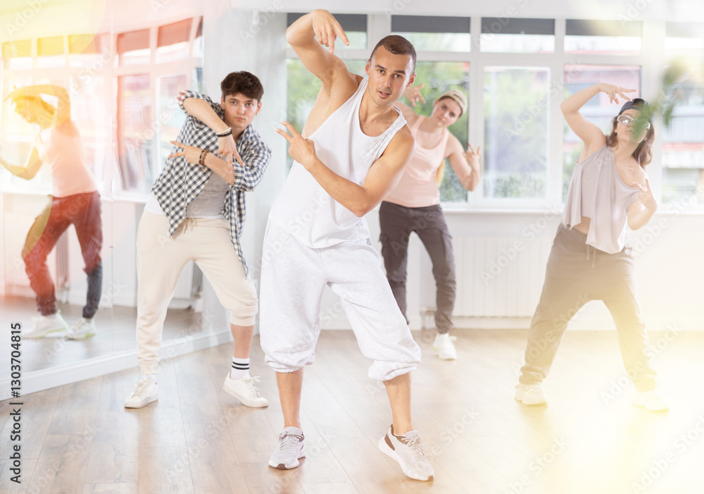 Guy makes movements and teaches group of hip hop fans to move beautifully and confidently to music, to control their bodies. Young boys and girl repeat after teacher Guy makes movements and teaches group of hip hop fans to move beautifully and confidently to music, to control their bodies. Young boys and girl repeat after teacher