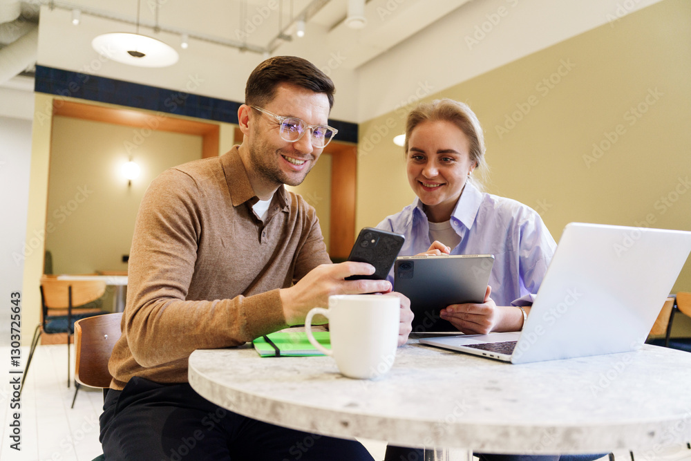 Colleagues collaborating on a project at a modern cafe during the afternoon