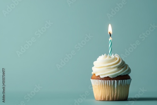 Delicious cupcake celebrating a birthday with lit candle on teal background