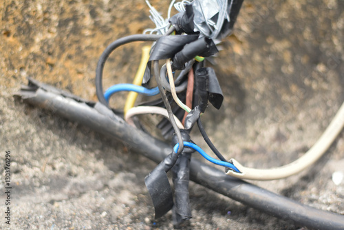 Damaged wires. Aluminum bare wires of electric cable or duct tape torn beside concrete poles. Selective focus
