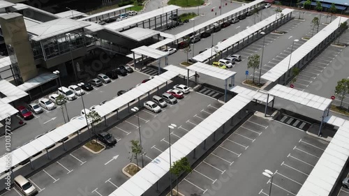 Aerial view of a public transport train station with cars parked.