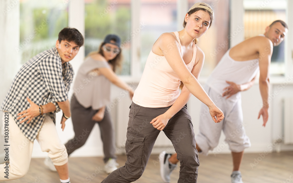 Naklejka premium Dynamic young woman training hip hop steps in dancehall during workout session