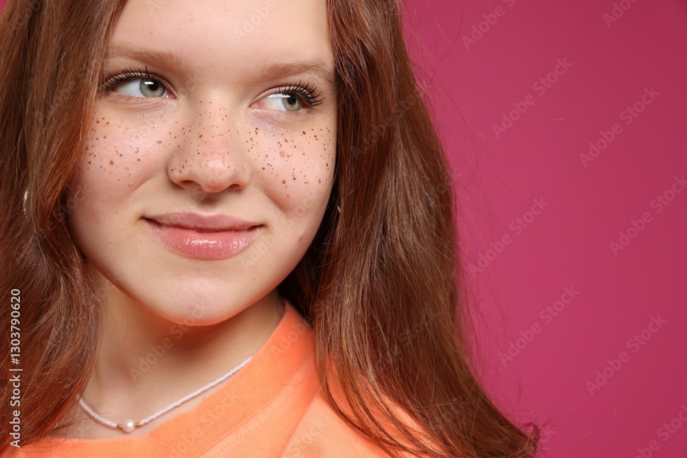 Fototapeta premium Beautiful teenage girl with freckles on pink background, closeup. Space for text