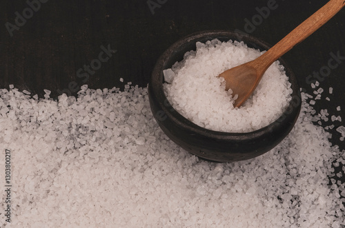 Salt in a wooden spoon on the table.