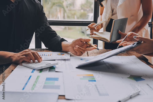 Asian businessman and woman working on laptop with digital tablet and analytical price charts at office desk, Business financial and accounting analytical concept.