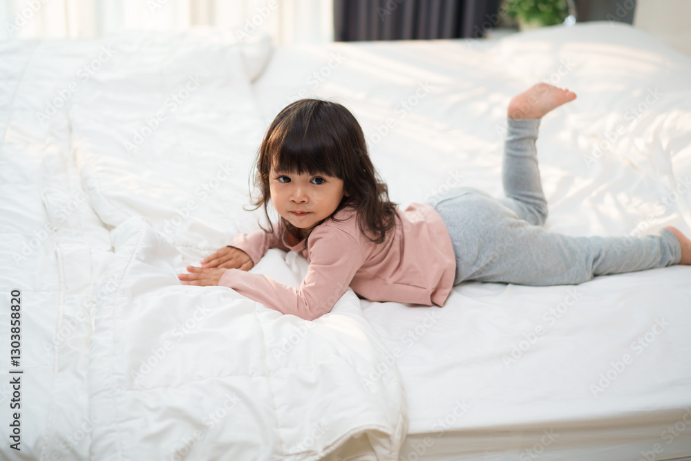 toddler girl lying on bed