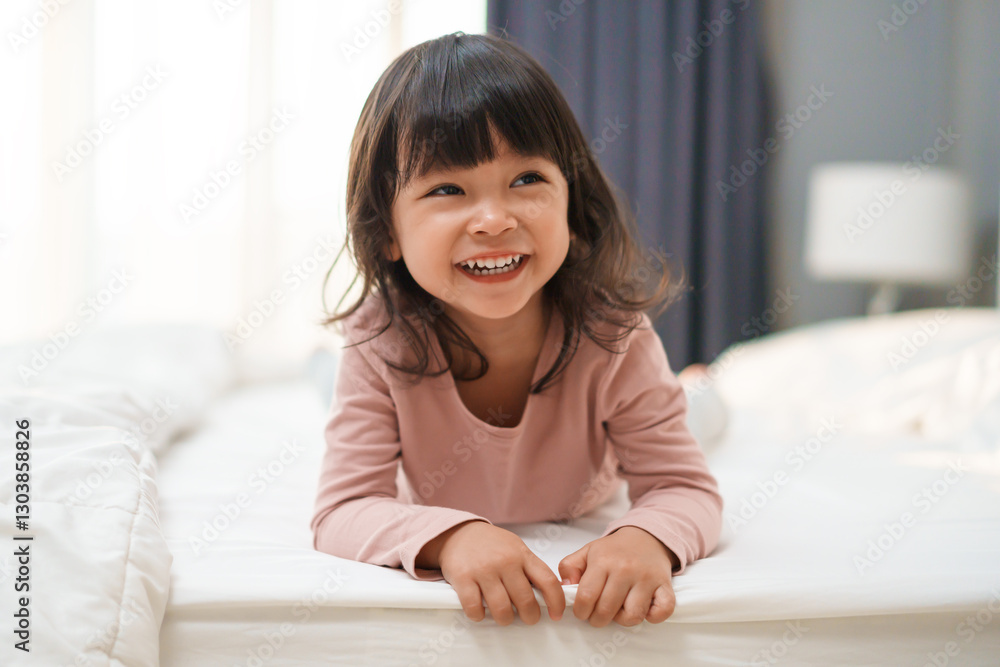 cheerful toddler girl playing and laughing on bed cheerful toddler girl playing and laughing on bed