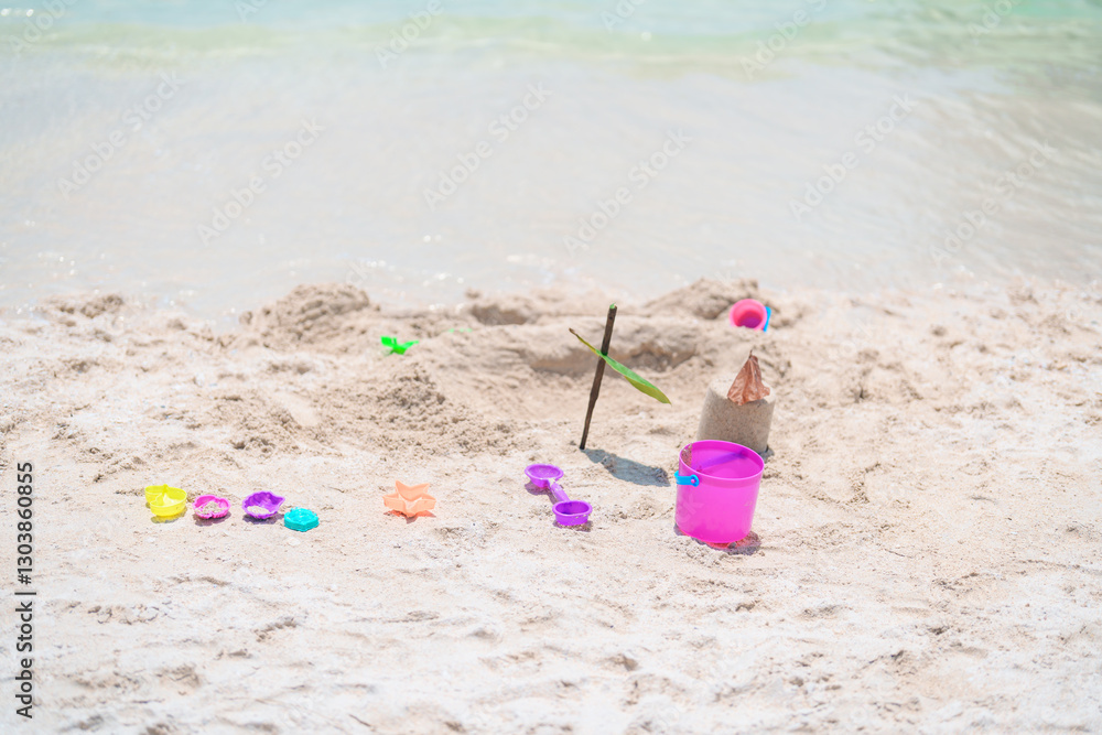 colourful beach toys on tropical beach, Children bucket, spade and other toys on beach against beautiful sea. Summertime and vacation Concept colourful beach toys on tropical beach, Children bucket, spade and other toys on beach against beautiful sea. Summertime and vacation Concept
