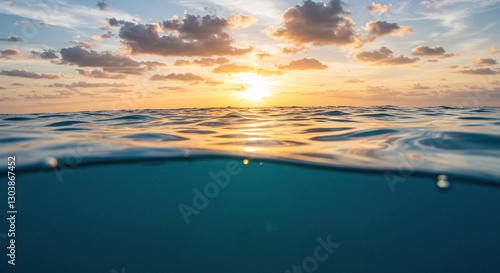 Fototapeta Naklejka Na Ścianę i Meble -  Sunset Ocean Half Underwater View: A view of the sunset over the ocean, half underwater and half sky