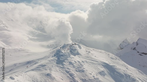 aerial view of a group of skiers descending a steep mountain slope