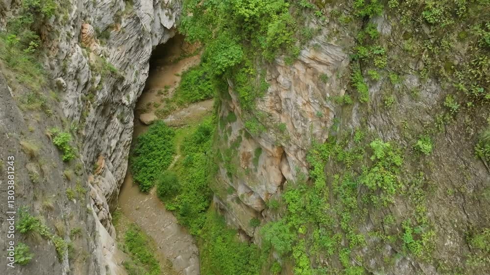 Aerial view of Karchagsu Gorge, Dagestan, showcasing a breathtaking rock pass between mountains with a winding river running below. Aerial view of Karchagsu Gorge, Dagestan, showcasing a breathtaking rock pass between mountains with a winding river running below.