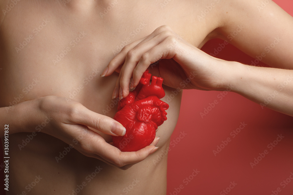 naked beauty woman body with red heart near left breast isolated on pink background
