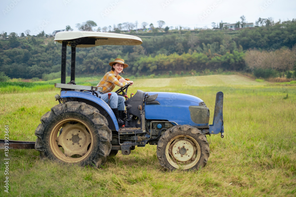 White woman sitting on tractor at grass field with smile. Female farmer with agricultural equipment with natural scenic view. White woman sitting on tractor at grass field with smile. Female farmer with agricultural equipment with natural scenic view.