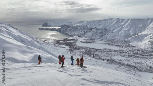 aerial view of a group of skiers descending a steep mountain slope