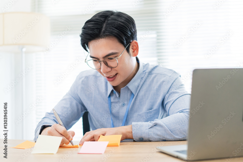 Young professional engaged in creative note-taking at a bright office workspace during daytime hours Young professional engaged in creative note-taking at a bright office workspace during daytime hours