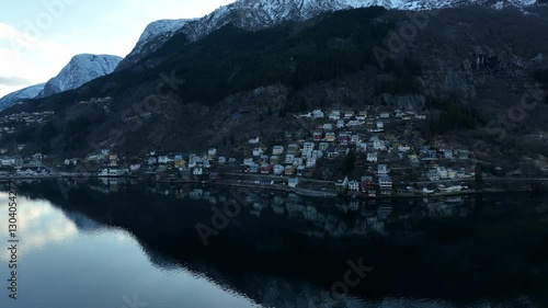 Aerial View of Kalvanes Neighborhood in Odda Norway at Dawn with Snow Capped Mountains photo