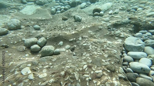 Underwater scene, sun rays, sun beam, fishes and rocks at Butterfly Valley Coast in Fethiye, Mugla, Turkey