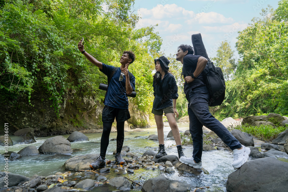 Obraz premium group of young asian men and woman take selfie photo together while trekking in the nature