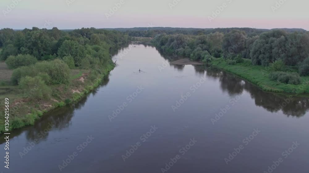 A serene river meanders through a vibrant landscape filled with trees and greenery. The sun sets in the background, creating a peaceful atmosphere in nature. A serene river meanders through a vibrant landscape filled with trees and greenery. The sun sets in the background, creating a peaceful atmosphere in nature.