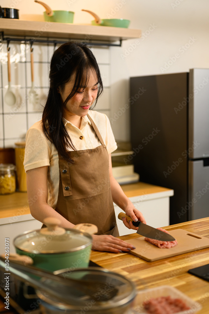 Young woman wearing a brown apron preparing Ingredients for spaghetti in a kitchen Young woman wearing a brown apron preparing Ingredients for spaghetti in a kitchen