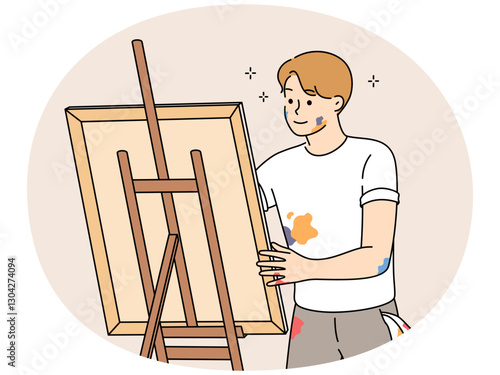 Young man drawing picture on easel