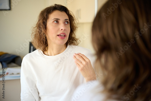 Wallpaper Mural Female doctor consulting patient in treatment office room. Osteopathic medicine and physiotherapy concept. Conversation between two pretty girls. Communication between two women Torontodigital.ca