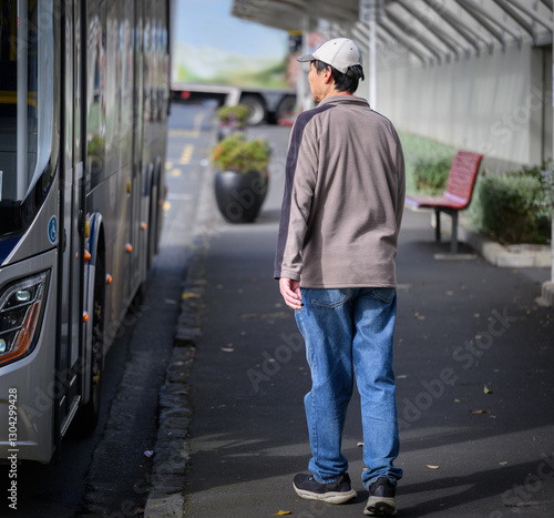 Obraz na płótnie Man walking to board the bus at bus stop. Auckland. w salonie