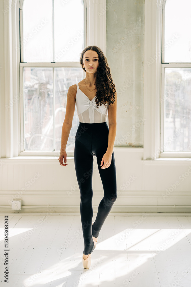 Ballerina stands en pointe in a sunlit studio with elegant poise Ballerina stands en pointe in a sunlit studio with elegant poise