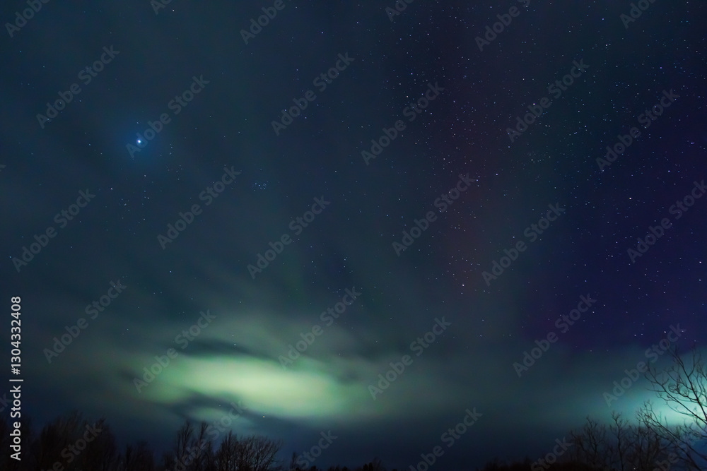 Northern Lights or Aurora Borealis on a winter night. Vibrant colors shimmer in the starry sky. Northern Lights or Aurora Borealis on a winter night. Vibrant colors shimmer in the starry sky.